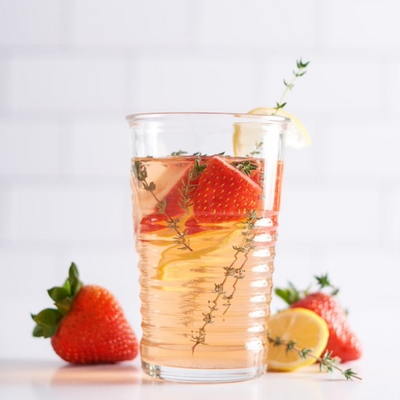 strawberries, cut up lemons, and thyme in a glass of water