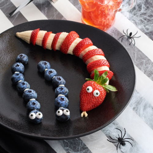 Blueberries and strawberries with a set of googly eyes on them to make it look like the berries are insects