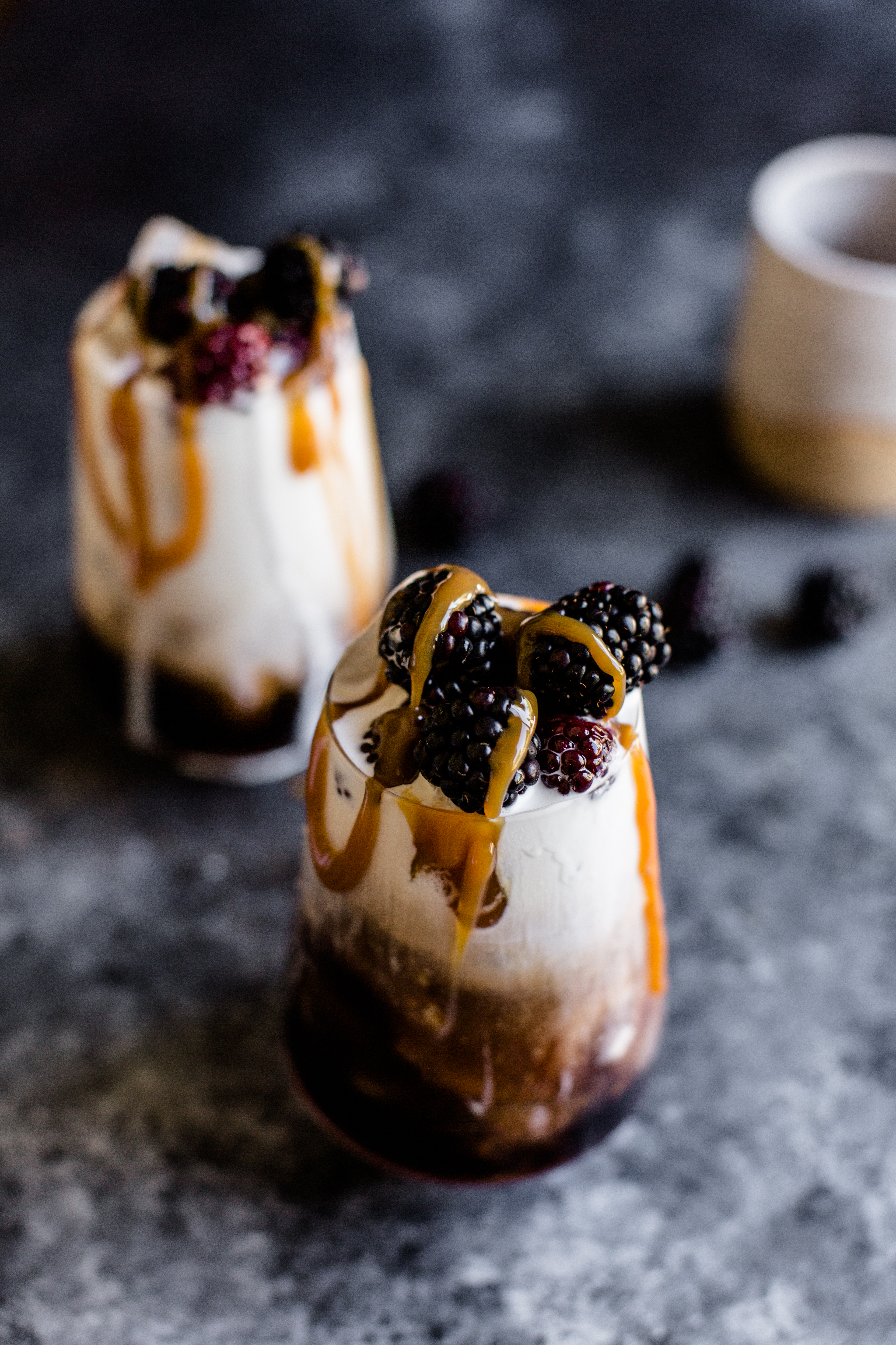 a white russian cocktail that has blackberries in it and a carmel drizzle